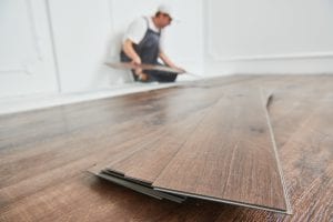 indoor floor installation. carpenter worker installing floor vinyl planks