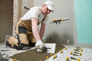 Tiler installing decoration ceramic tile on floor in bathroom. home indoors renovation