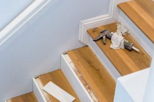 Hardwood Floor Installation On Stairs, Caulking Gun On Step, Baseboards Being Measured